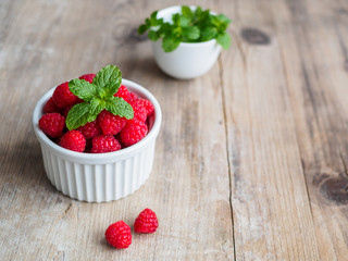 Frische Himbeeren und Pfefferminze in einer weißen Schüssel 