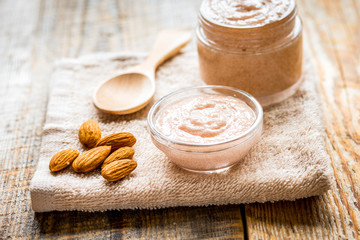 cosmetic set with almond scrub on table background