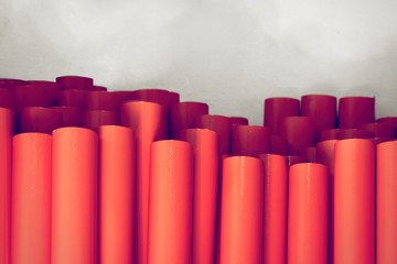 Metal pipes, stand upright. Painted in orange. Concept backgrounds of metal industry.
