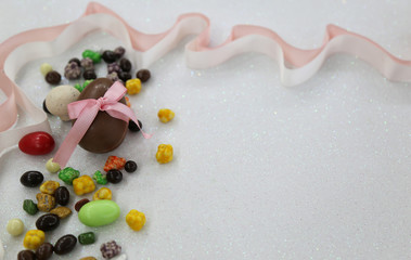 Easter composition with chocolate eggs on color wooden background, space for text