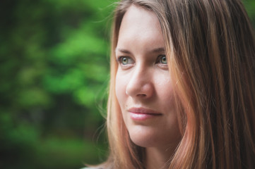 Fototapeta premium Portrait of beautiful woman on green summer background