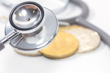 stethoscope and gold bitcoin on white background