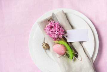 Easter dinner. Elegance table setting spring pink flowers on pink linen tablecloth. Top view.