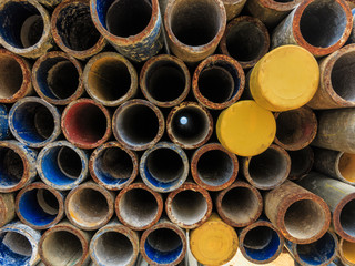 Mental scaffold pipe stack together on scaffold plank wood shelve with blue, green and yellow mark at the tip for build the temporary structure.