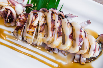 Grilled Squid with sauce on white plate