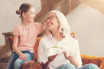 My dear child. Pleasant nice aged woman sitting in the armchair and smiling to her granddaughter...