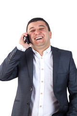 Portrait of a young man dressed in a white shirt and black suit, which speaks on the mobile. Isolated on white