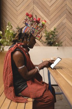 Maasai man in traditional clothing using digital tablet