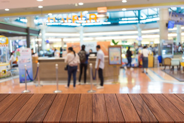 Wooden table in front of a blank background blur abstract of a shopping mall. Can be used for display or editing. products.Mock Your place for display of products.