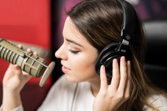 Latin female singer singing at radio station