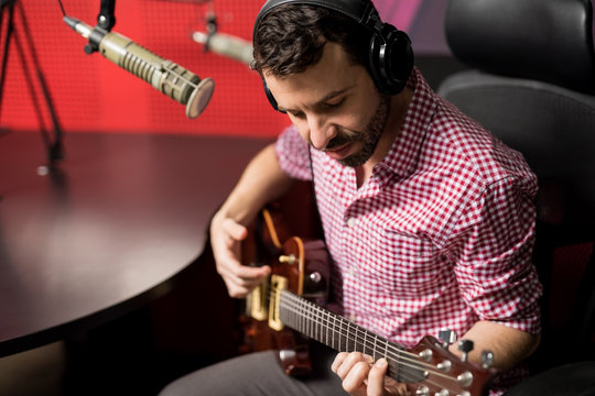 Music artist playing guitar in radio show