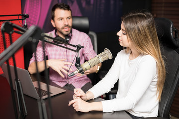 Radio hosts moderating a live show at station