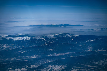 Fototapeta na wymiar Airplane view on the beautiful alpine mountains top, covered with ice.