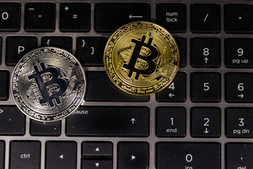 Golden and silver bitcoins on laptop keyboard
