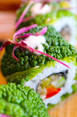Vegetarian sushi roll, made of vegetables on a wooden plate. Healthy vegan food concept, macro view.