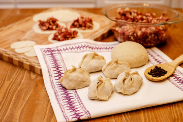 Manti dish. National Uzbek dish with meat and onion. Raw manti on a solid background with flour.