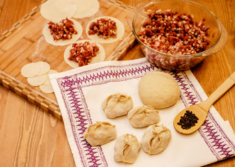 Manti dish. National Uzbek dish with meat and onion. Raw manti on a solid background with flour.