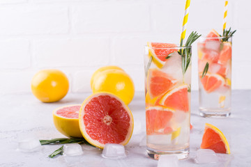 Mineral infused water with grapefruit ice, and rosemary on white background, homemade detox soda water recipe.
