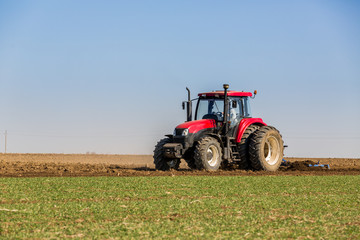 Tractor cultivating field at spring