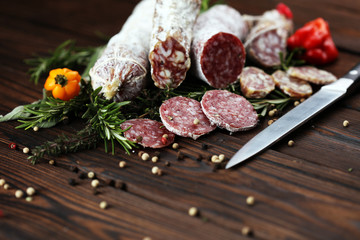 thinly sliced salami on a wooden texture on the background.