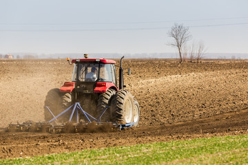 Tractor cultivating field at spring