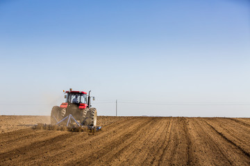 Tractor cultivating field at spring