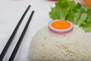 Rice with vegetables on white plate on light background