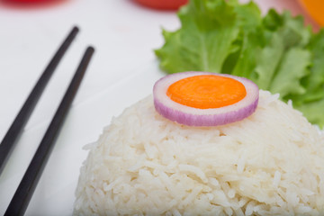 Rice with vegetables on white plate on light background