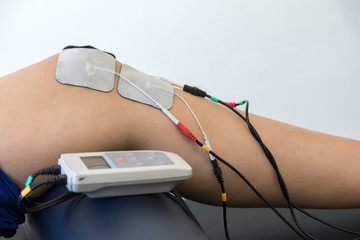 electronic therapy on knee used to treat pain. selective focus