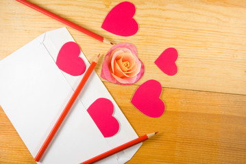 image of notebook, pencils, stylized hearts,rose flower