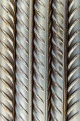 Steel reinforcing bars rods with periodic profile, lying vertically. Industrial abstract background. Close-up.