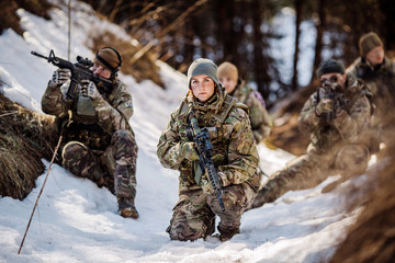 Fototapeta premium team of special forces weapons in cold forest. Winter warfare and military concept