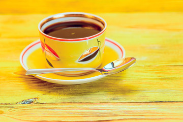 tea in a yellow mug on a wooden background