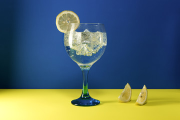 gin tonic with  lemon slice on blue