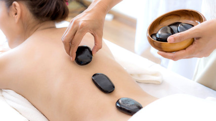close up beautiful and healthy woman  during a back stone therapy massage in spa salon