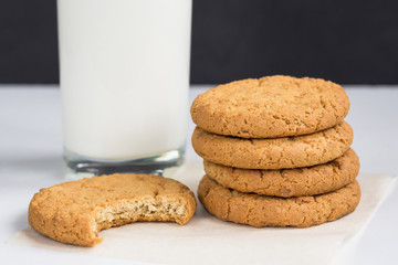 cookies and glass of milk. Stack of oatmeal gingerbread on white wooden table with black background. concept of healthy breakfast