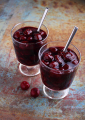 Kissel with cherries in a glass on an old background