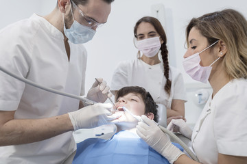 A portrait of a dentist with his team working
