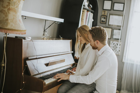 Loving couple playing piano.