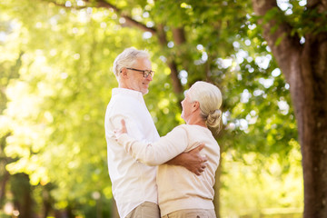 old age, relationship and people concept - happy senior couple dancing waltz at summer park