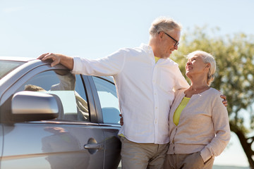 road trip, travel and old people concept - happy senior couple with car in summer