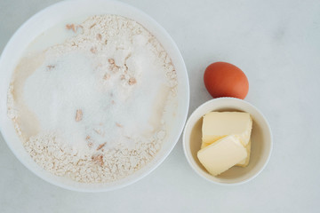 Preparation of the dough. The rolled out dough with the ingredients - flour, eggs,  and cooking instruments . On a white wooden background. Top view