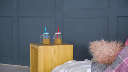 leisure relaxation home party. two coffee - like drinks in jars with straw on the small table.