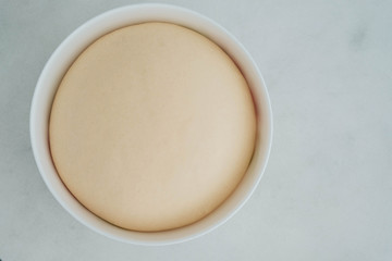 Fresh yeast dough in a bowl for pizza or bread. cooking courses. selective focus.