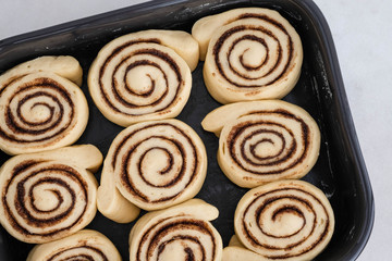 Cinnamon rolls or cinnabon handmade raw dough preparation with spices. Sweet Homemade Pastry christmas baking. Kanelbule - swedish dessert. Top view.