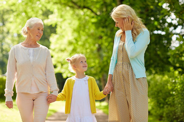 family, generation, women and people concept - happy smiling mother with daughter and grandmother...