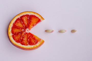 a round slice of red orange, three seeds