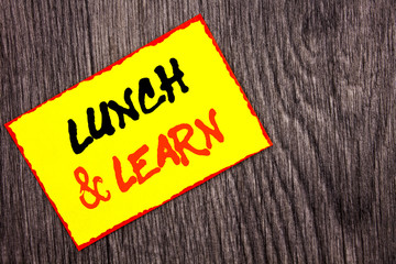 Conceptual hand writing text showing Lunch And Learn. Concept meaning Presentation Training Board Course written on Yellow Sticky Note Paper on the wooden background.