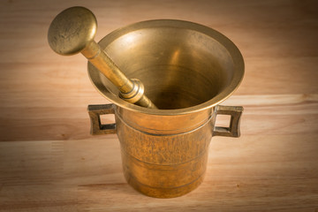 Mortar made of brass standing on a wooden table