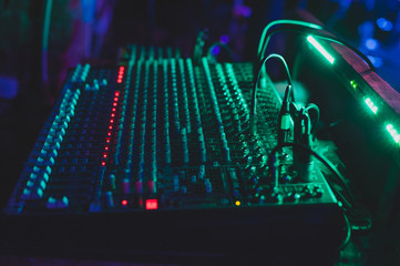 Sound mixing console in a nightclub. Dark soft blurry photo